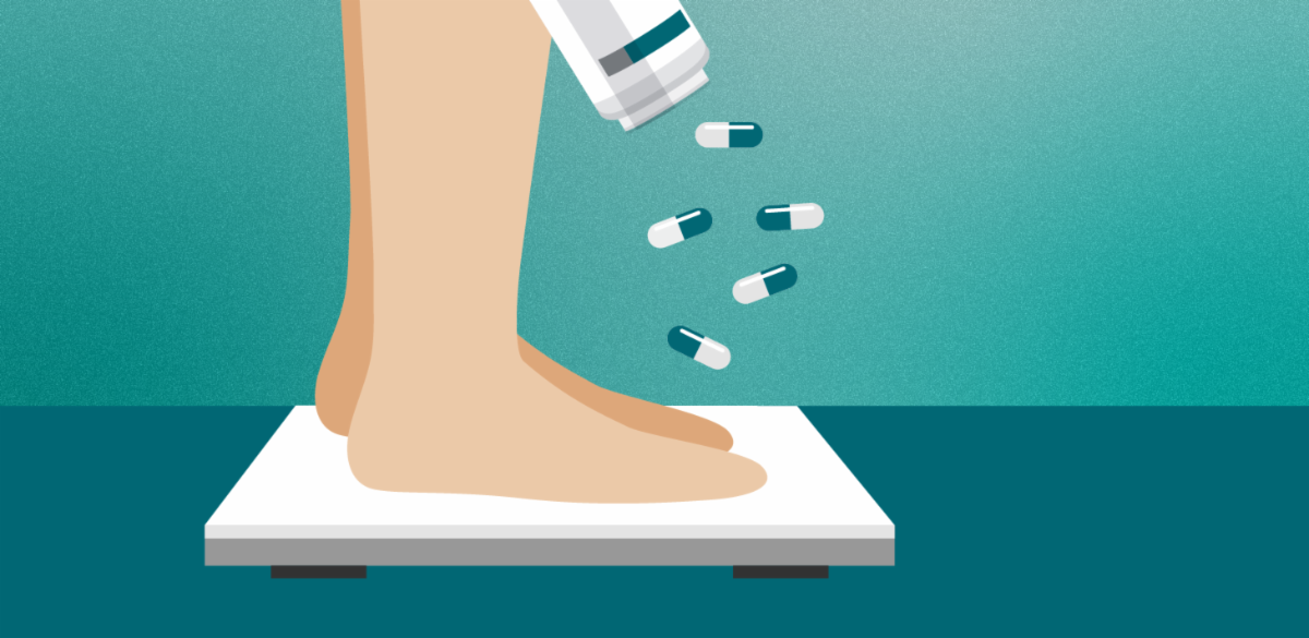 Feet on a scale next to a bottle of pills