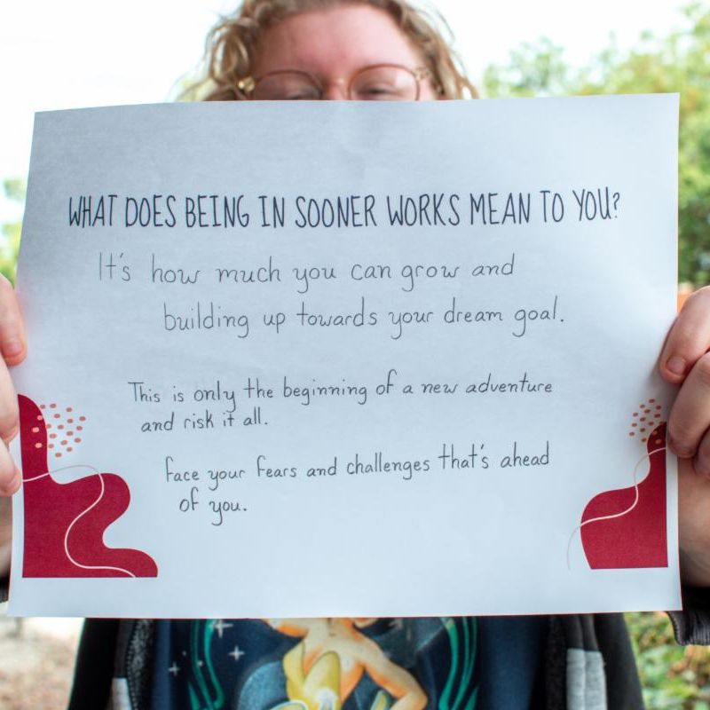 Person holding a sign over their face with IPSE logo does being in sooner works mean to you Its how much you can grow and build up towards your dream goal. This is only the beginning of a new new adventure and risk it all face your fears and challenges