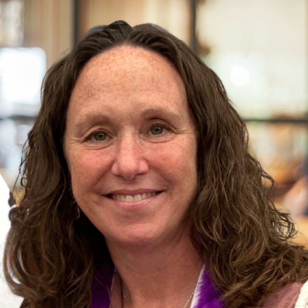 Headshot of a woman with brown hair and dark eyes 