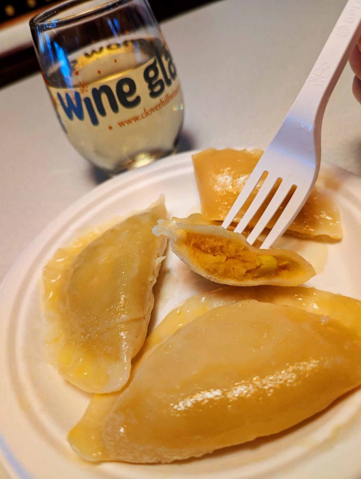 plate of three pierogis and a glass of wine