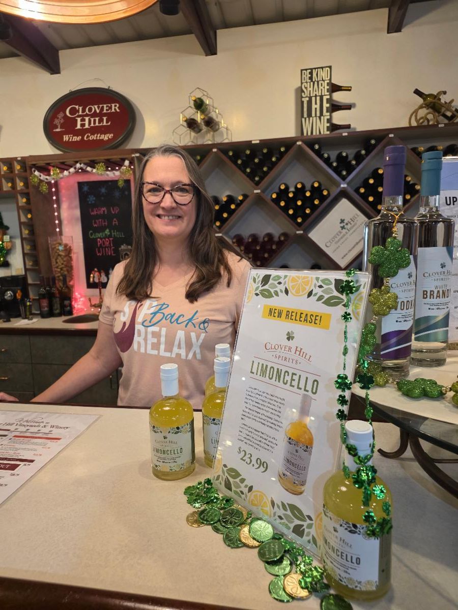 Clover Hill employee standing near bottles of Limoncello at the farmers market store