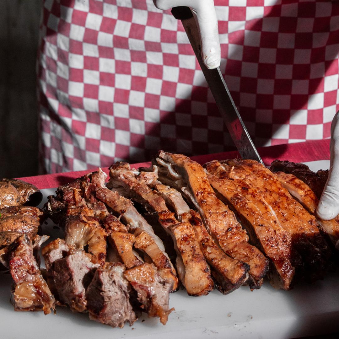 Close up of person cutting smoked meat with a knife