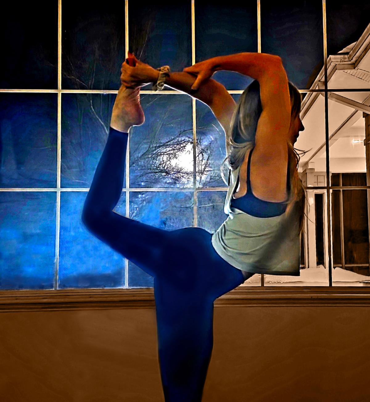 woman doing yoga pose in front of large window with full moon in the background