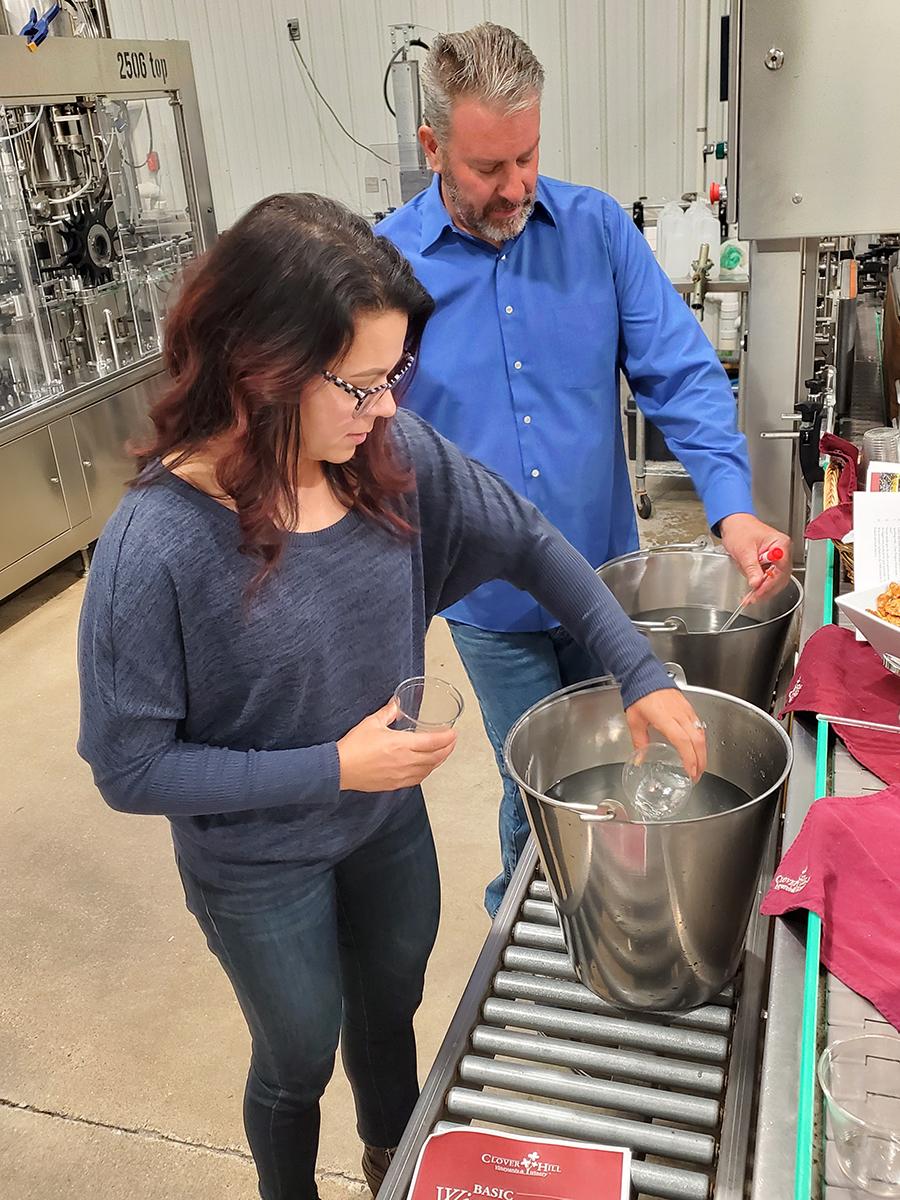 Winemaker John Skrip III assists customer with learning to make white wine