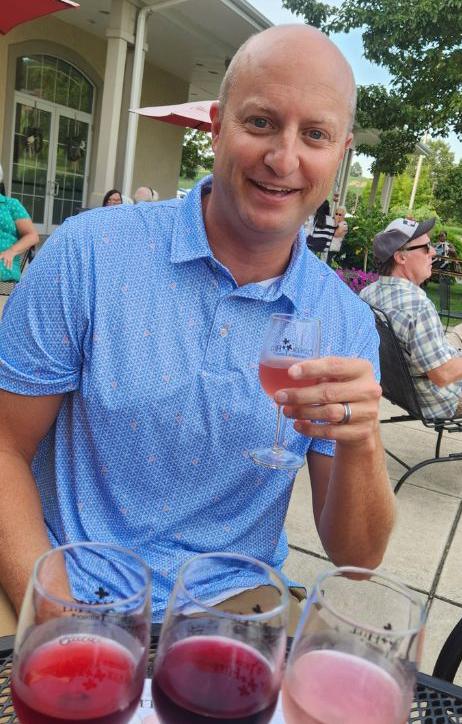 Man holding a glass of Clover Hill wine