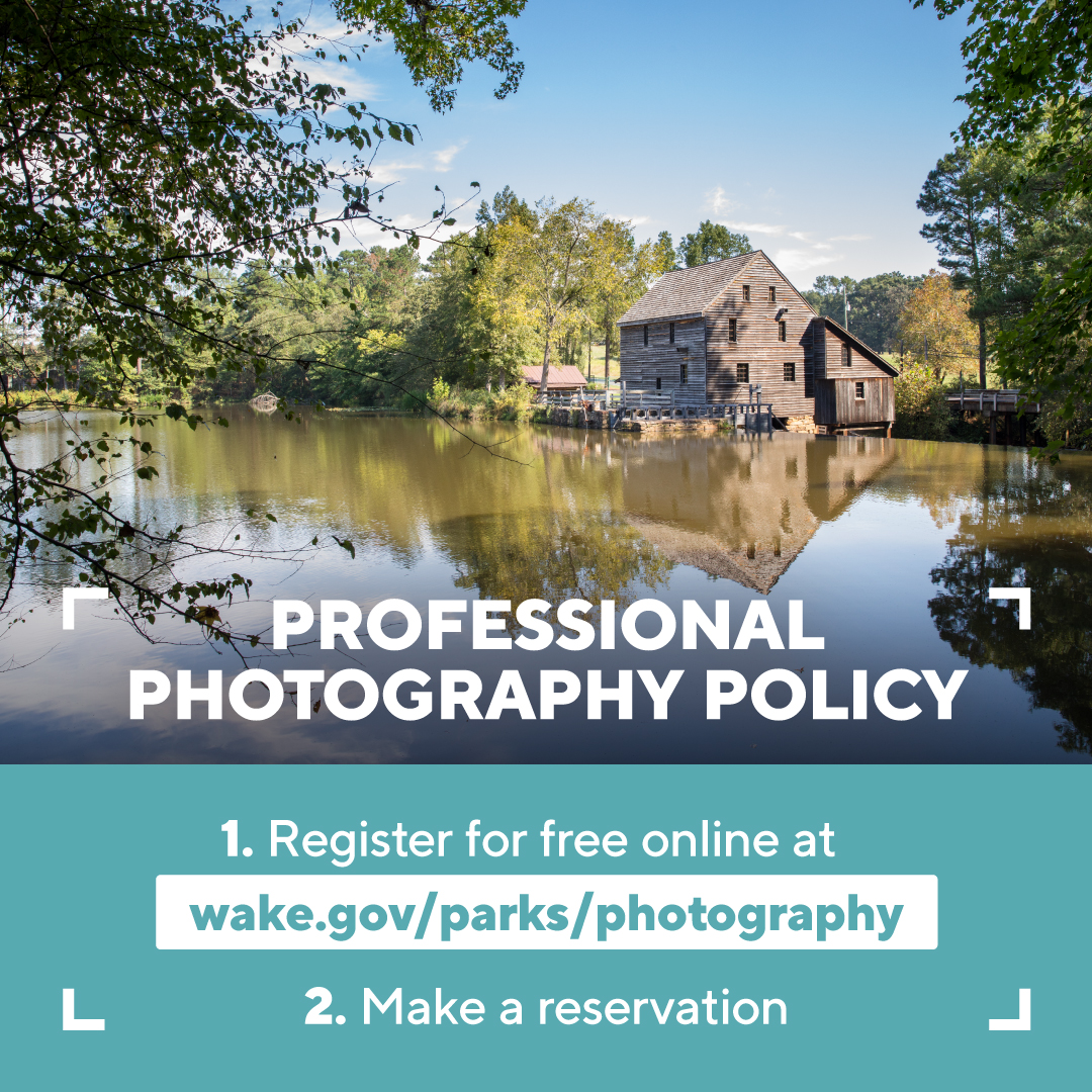 View of the historic gristmill from across the pond with text giving website to register for photo permit