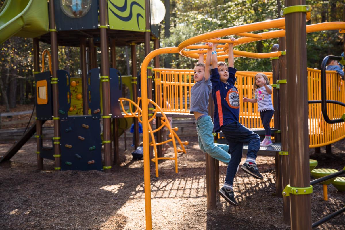 Young boys play on monkey bars in playground