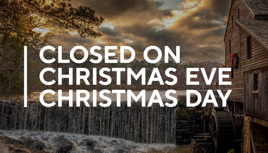 Picture of gristmill against backdrop of setting sun on cloudy day with text stating Closed on Christmas Eve and Christmas Day