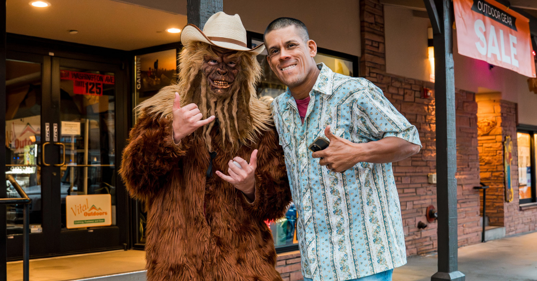 A person dressed up as Sasquatch takes a picture with another person in downtown Golden