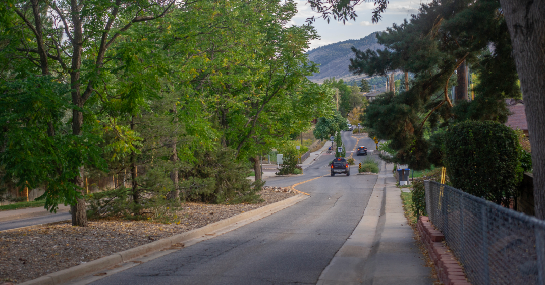 A car drives south on North Ford Street in a wooded neighborhood in Golden