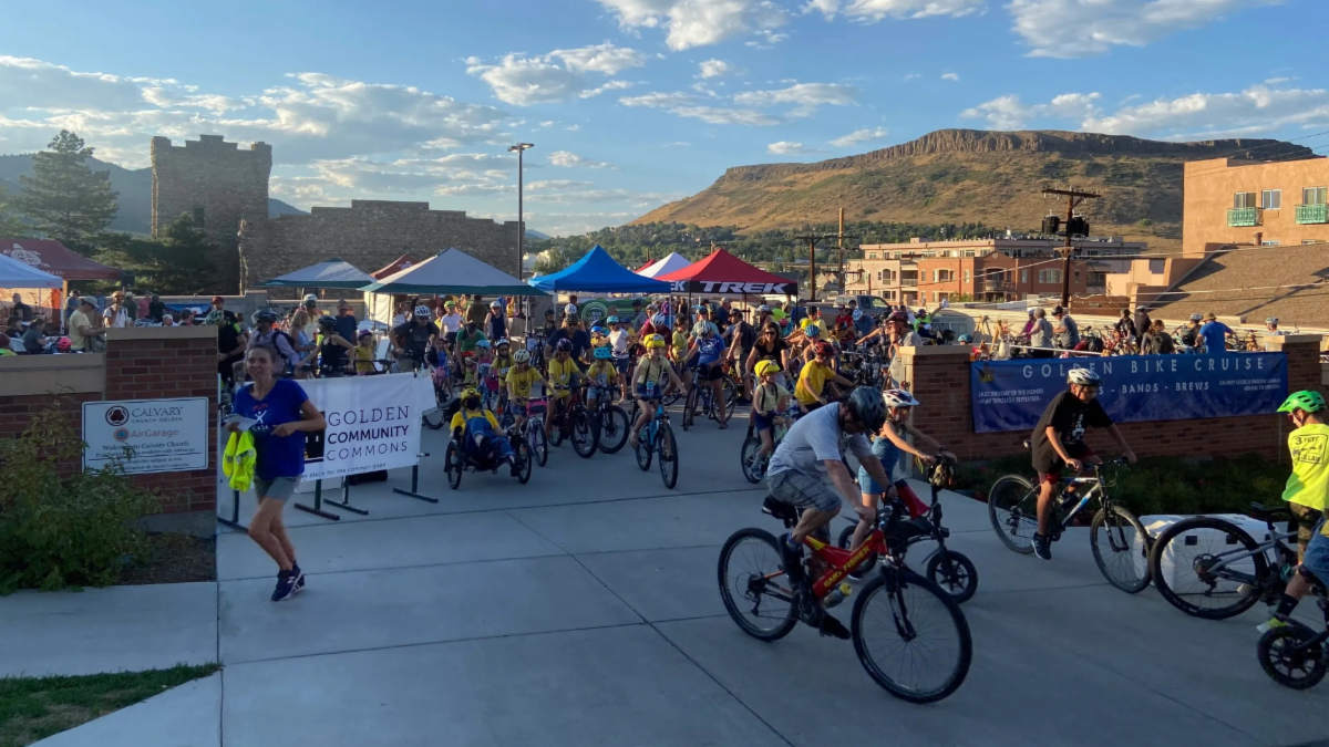 People bike at a bike festival at sunset in Golden