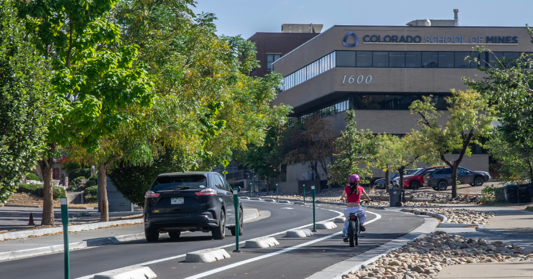 A person rides in a bike lane next to a car