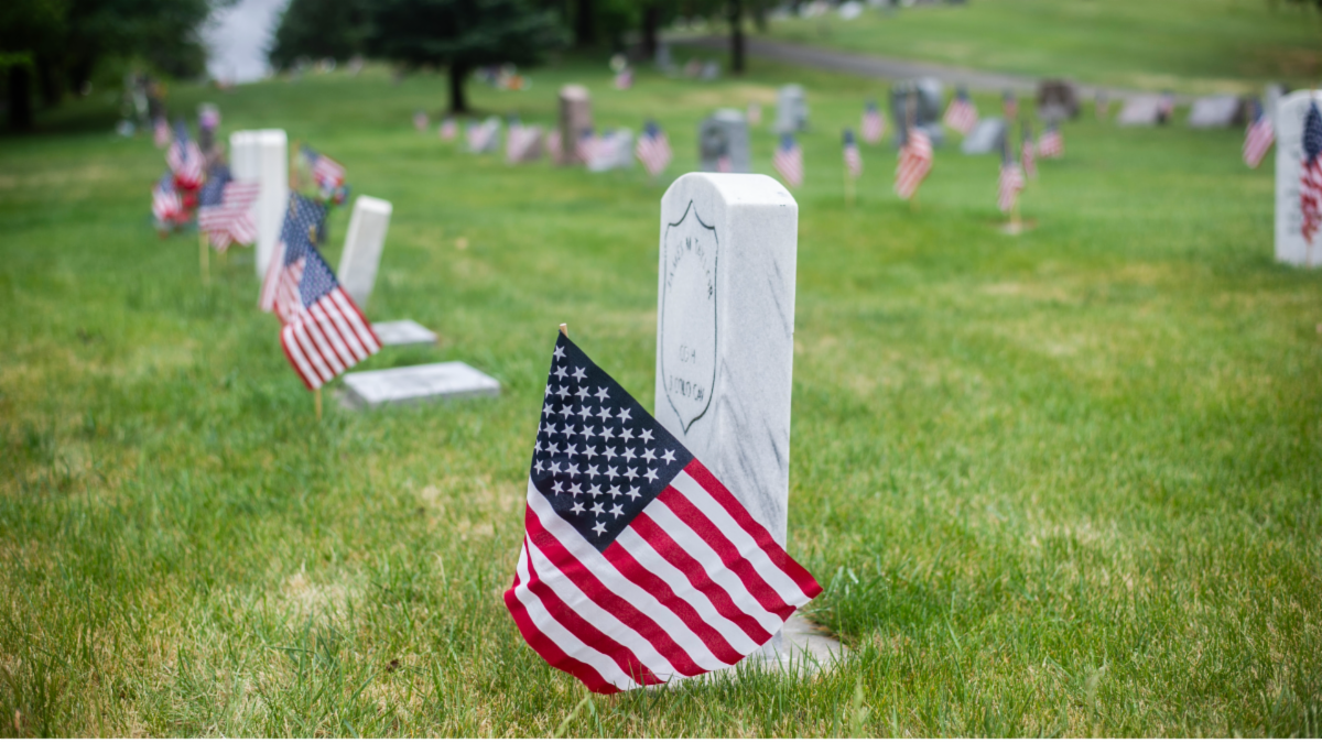 Flags planted next to tombstones in a cemetery