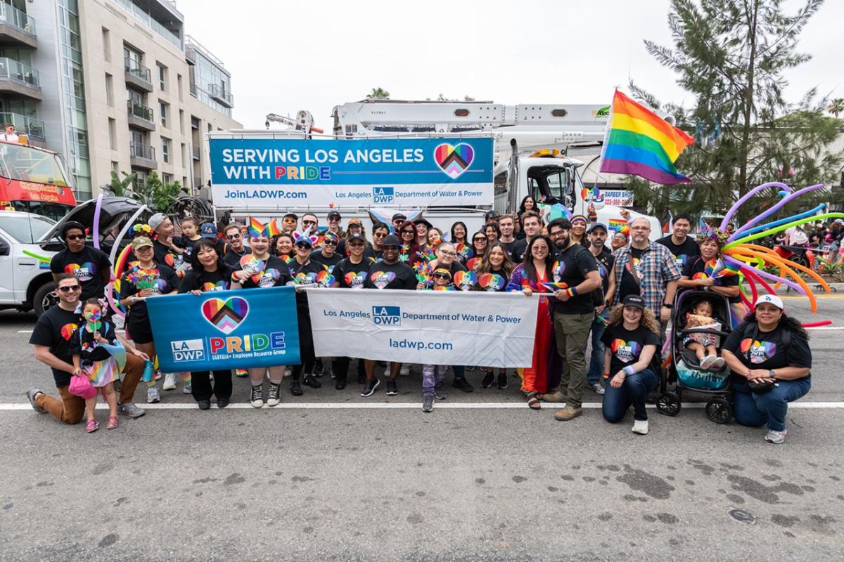 A group of people posing for a photo while holding banners with a large truck in the background