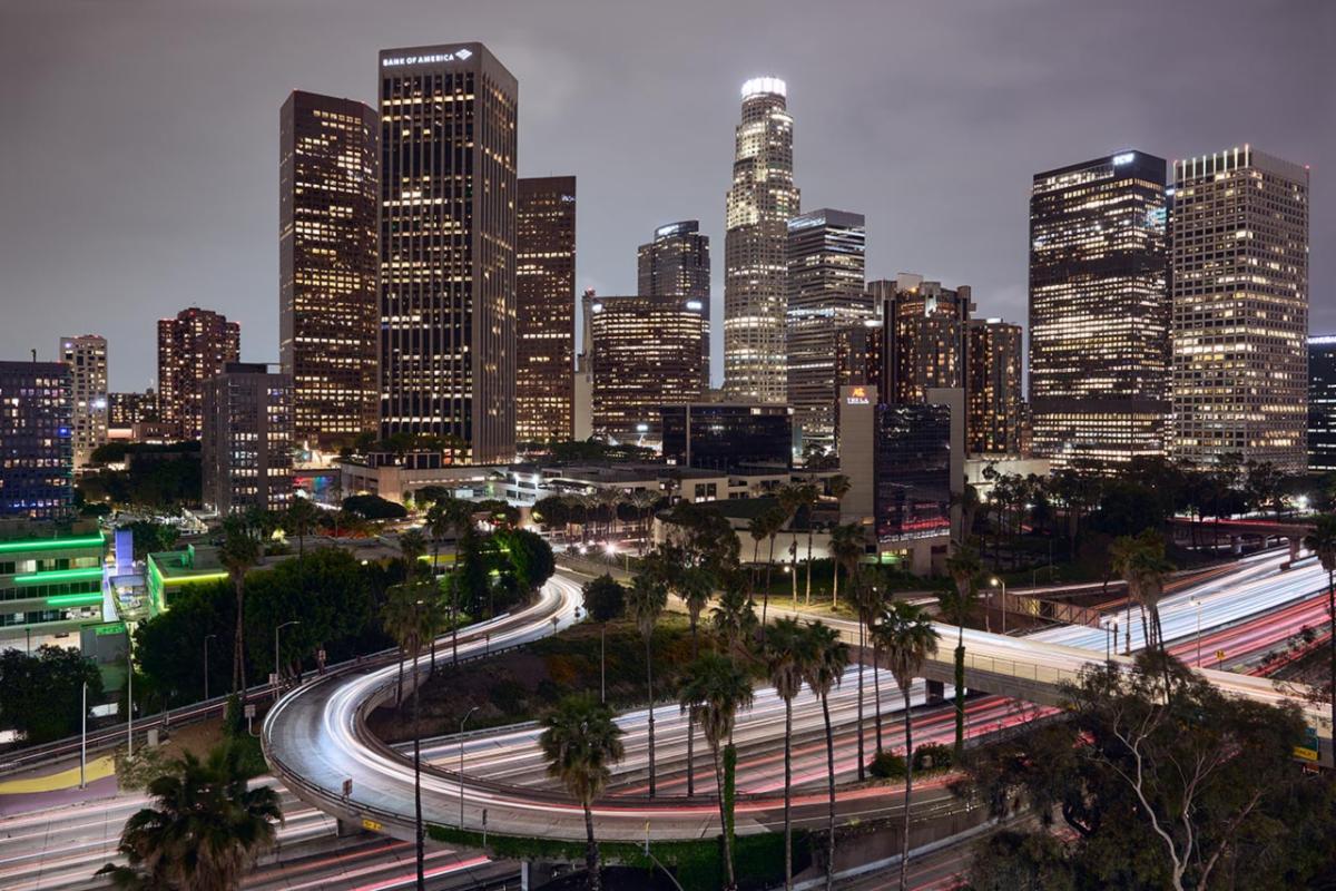 City skyline at night with buildings and traffic lights. 
