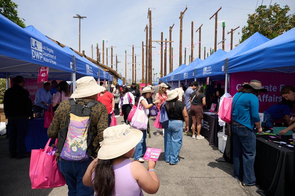 Crowd of people walking outside, visiting various LADWP career booths.