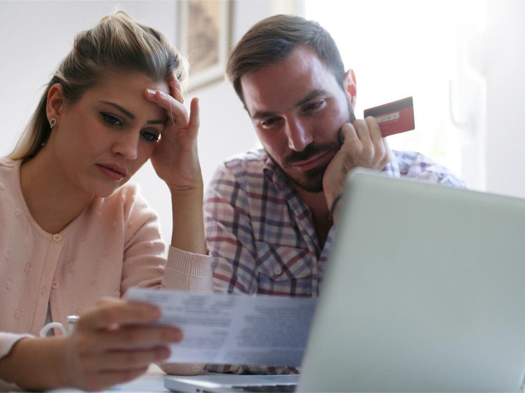 Man and woman reviewing bills at computer