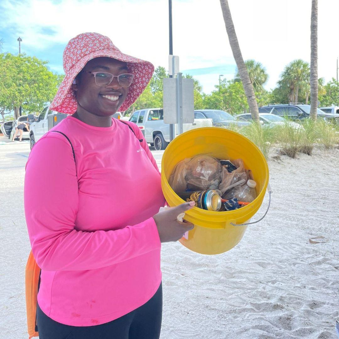 woman holding bucket with trash in it