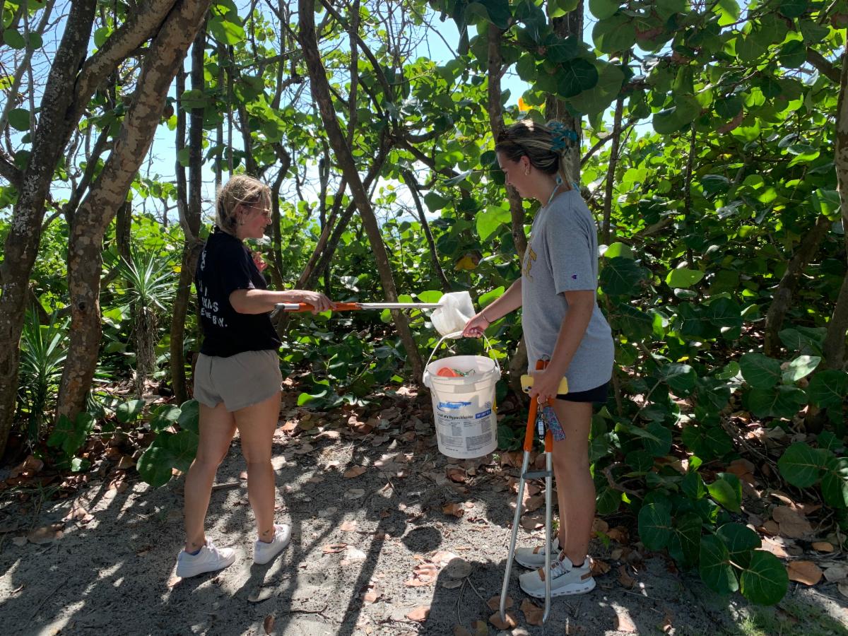 2 ladies picking up debris at the park
