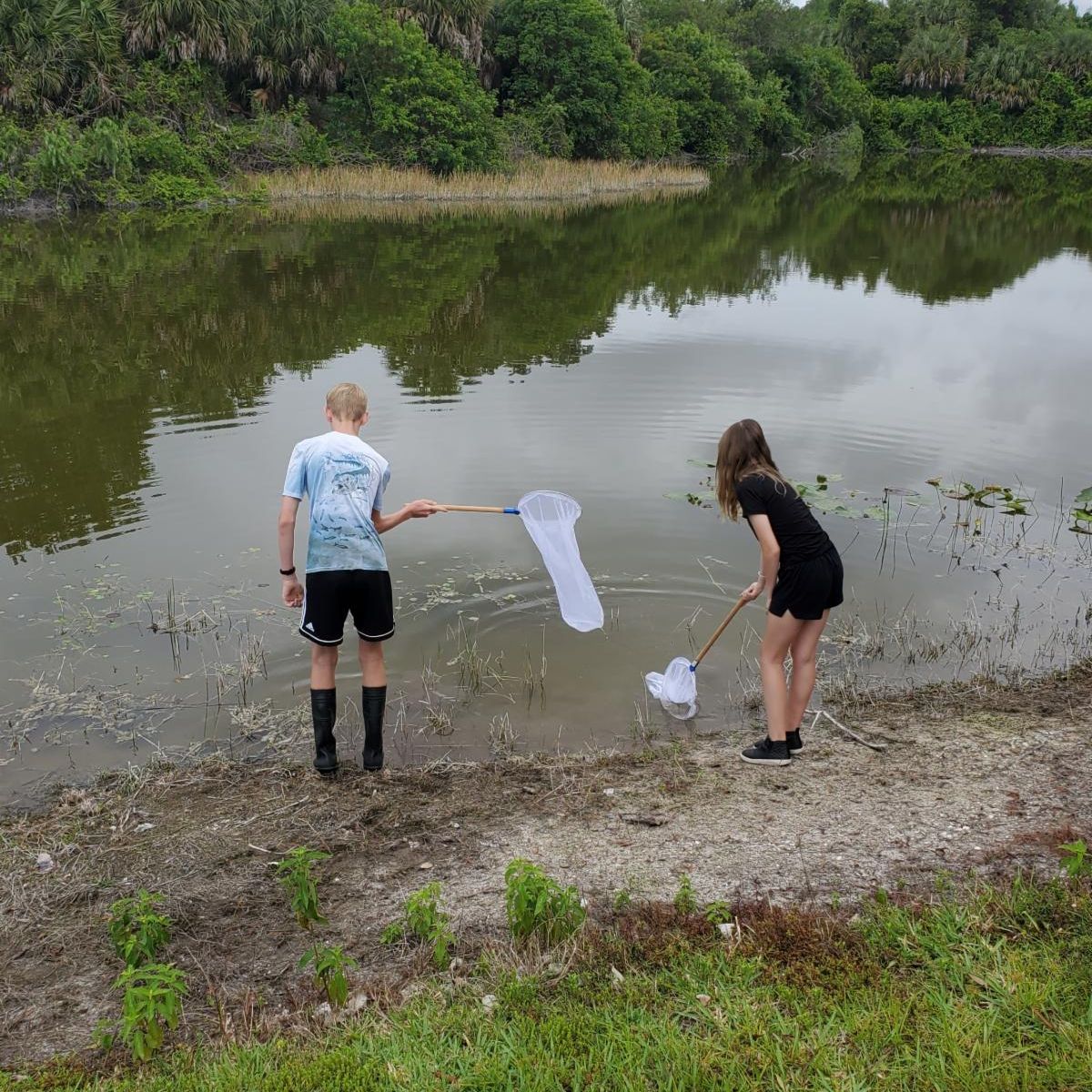 people dipnetting by a small body of water