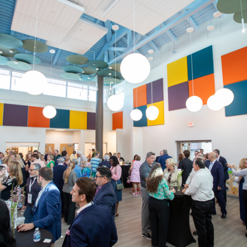 Attendees networking inside a bright, modern Parc Center for Disabilities facility with colorful wall panels and high ceilings