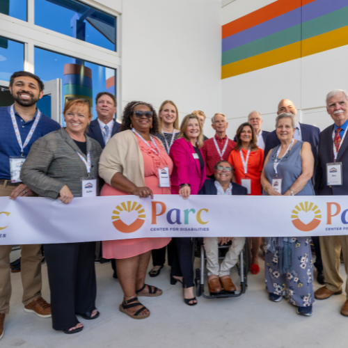 Group of community members and staff smiling at a Parc Center for Disabilities ribbon-cutting ceremony