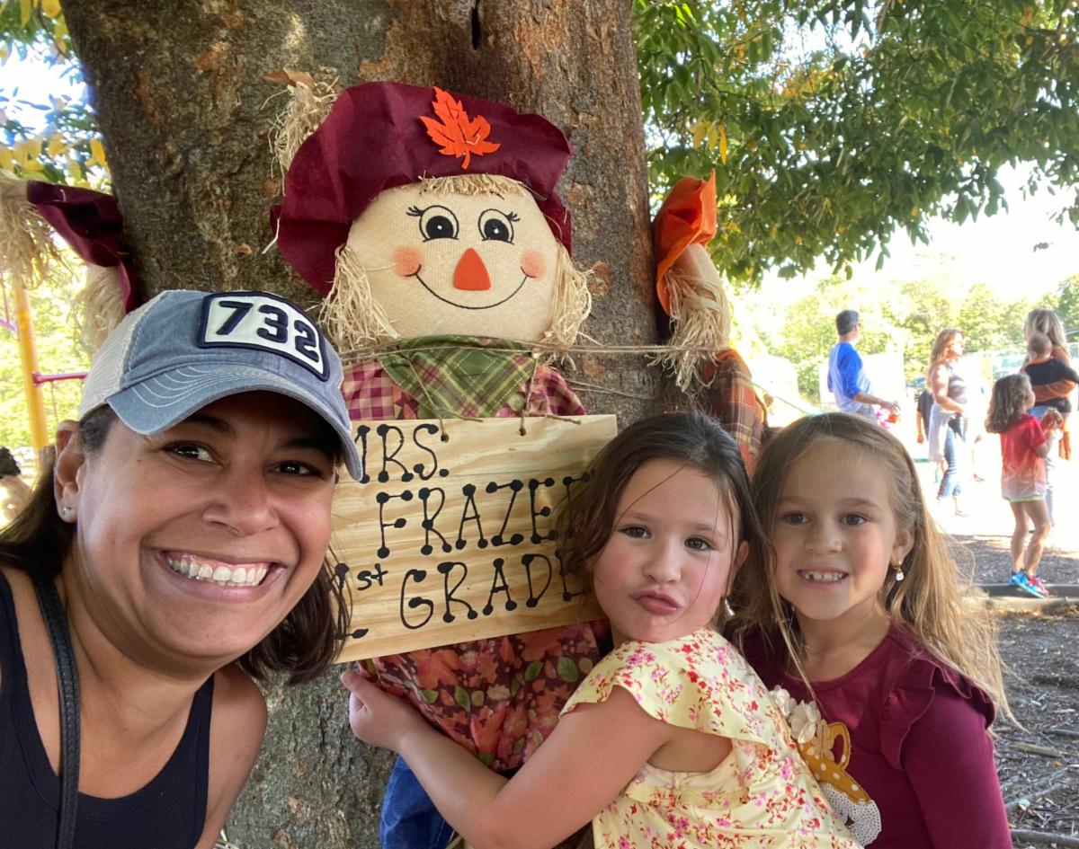 Navesink students and their teacher pose next to a scarecrow at the school's Fall Fest.