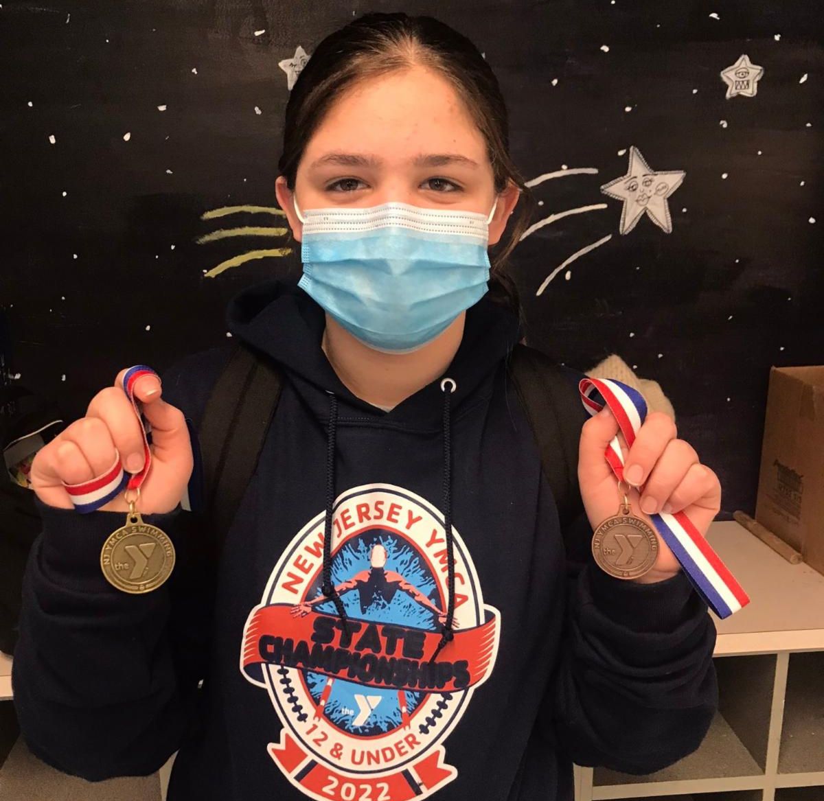 Natahly Murphy Restuccio of Thompson Middle School poses with the gold and bronze medals she won at the 2022 YMCA Swimming State Championship meet.