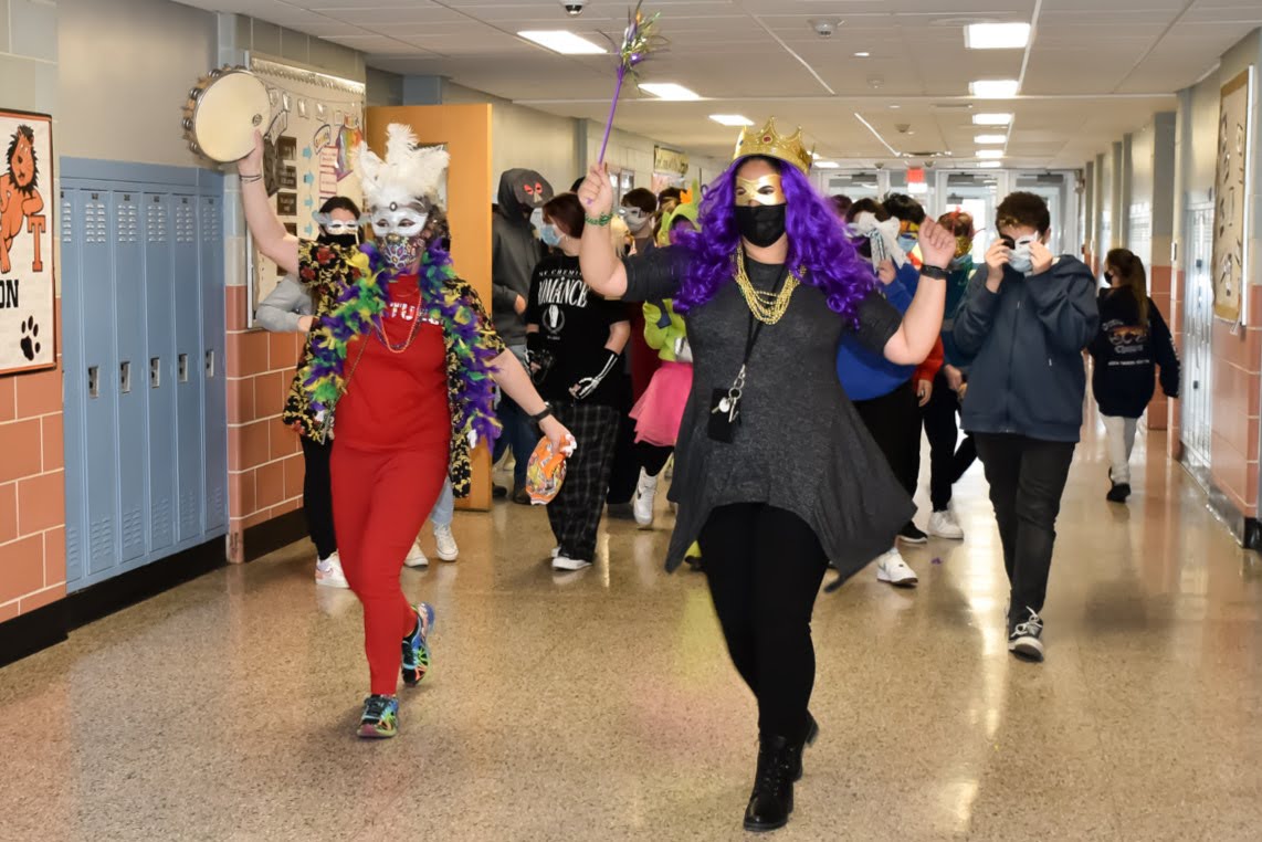 Students and teachers at Thorne Middle School wear masks and march in a parade down the hall way as part of Mardis Gras celebration.