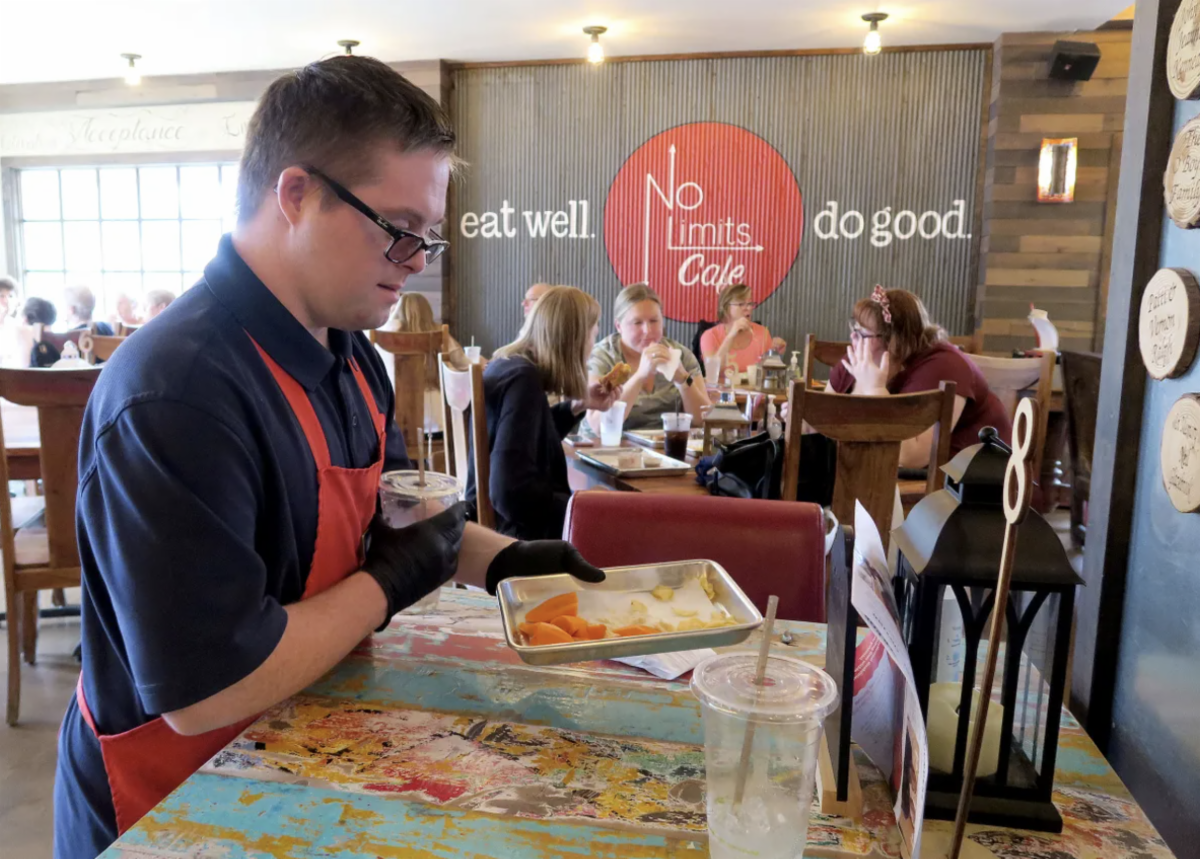 No Limits Cafe waiter delivers food to customers.
