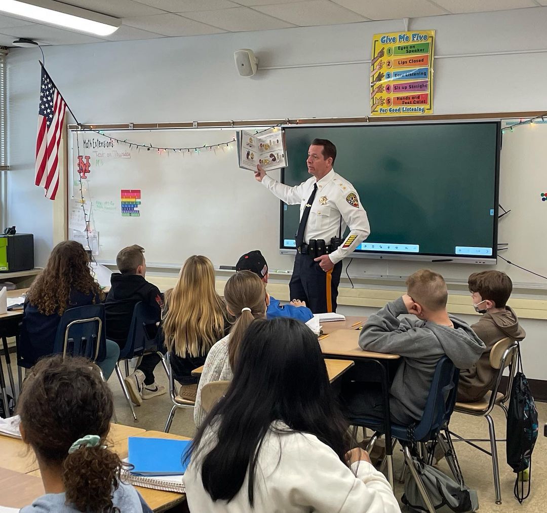 Middletown Township Police Department Chief, Craig J. Weber, is surrounded by Lincroft Elementary School students while reading a book to the group.