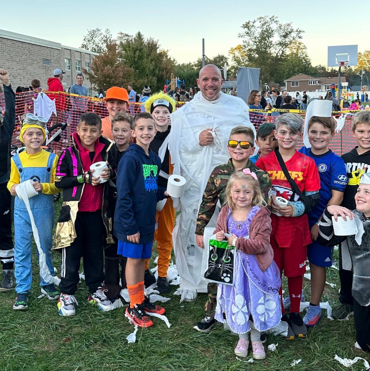 New Monmouth students and principal Matt Ferri pose together in costumes.