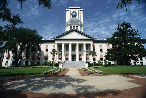 This is the State Capitol building in Florida. It has a large concrete stairway leading up to it with large columns holding up the facade.