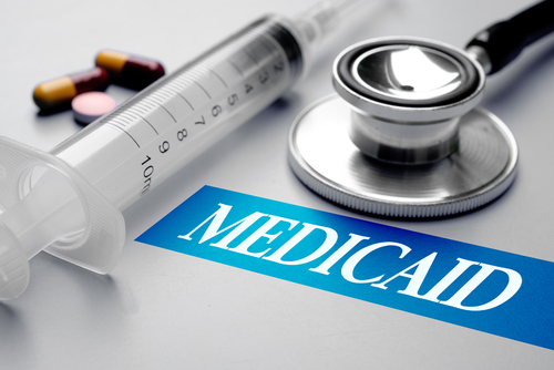 Medicaid_ health concept. Stethoscope_ syringe and pills on grey background. Selective focus image. 