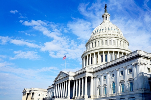 United States Capitol Building in Whashington DC with Flag on a bright sunny day with blue sky