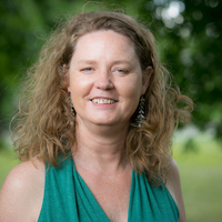White woman with wavy blonde hair smiling at the camera