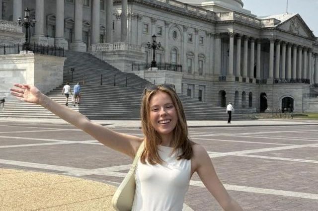 young white woman with red hair standing in front of the US Capitol smiling