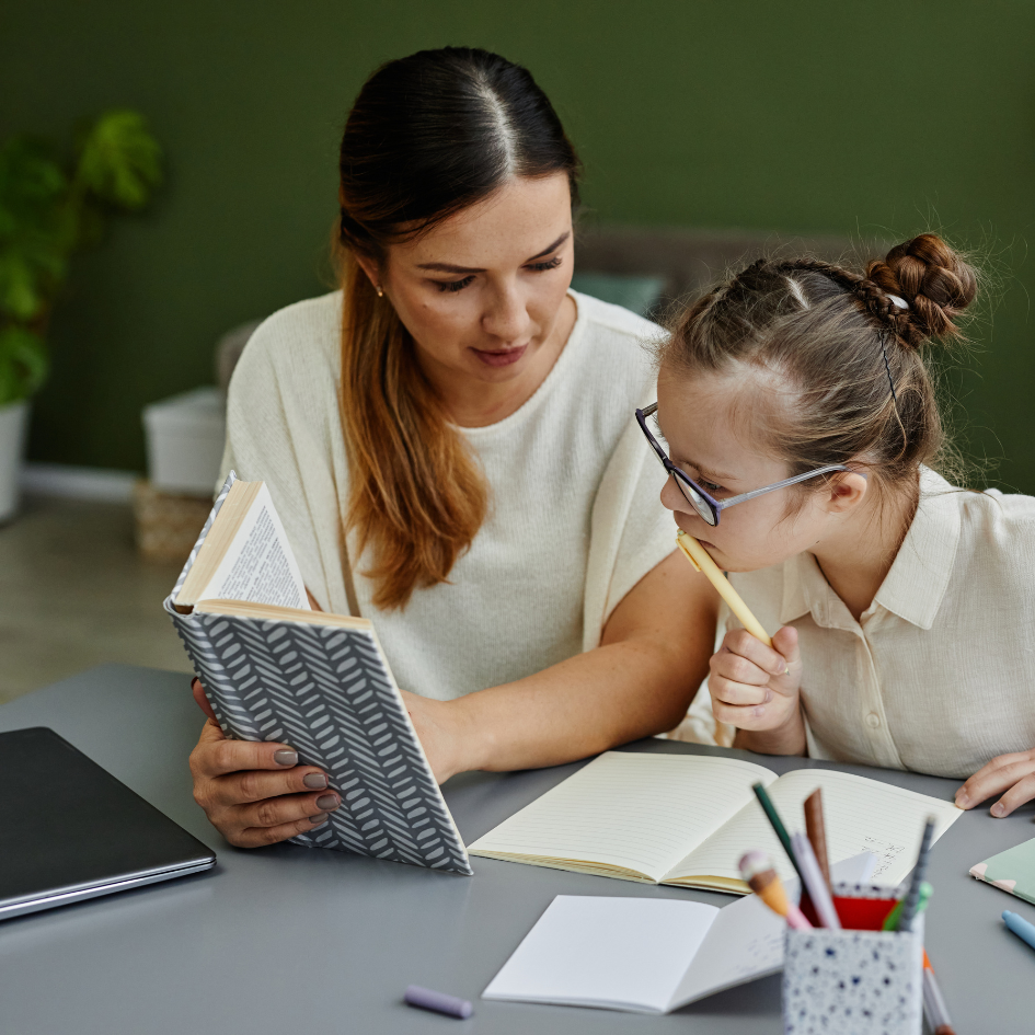Image of a woman helping a child with schoolwork