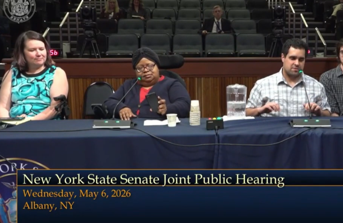 Three disability advocates provide testimony before a New York State Senate Joint Public Hearing in Albany. Seated at a witness table with microphones, they share perspectives on employment opportunities and policies affecting people with disabilities. The hearing took place on May 6, 2026.