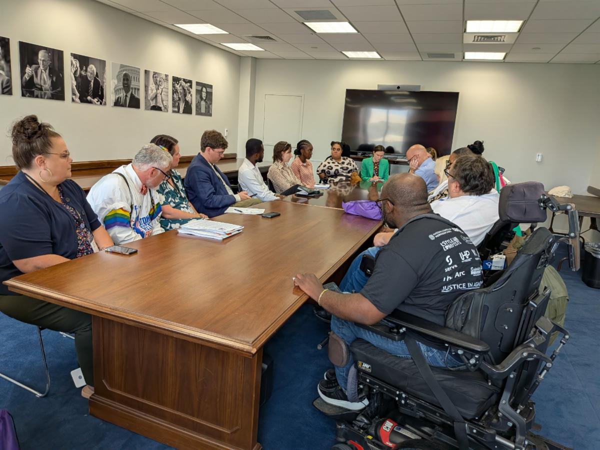 Disability advocates and Independent Living leaders participate in a meeting around a conference table during a legislative advocacy day.