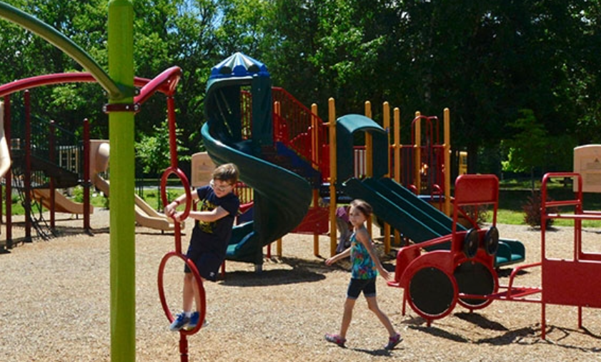 2 children playing on a playground outside on a sunny day 