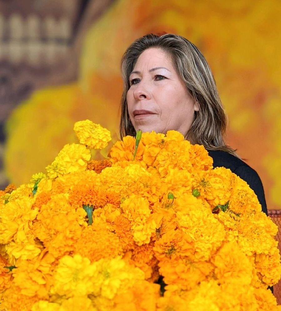 Anastasio's widow Maria Puga holding a large bunch of marigolds