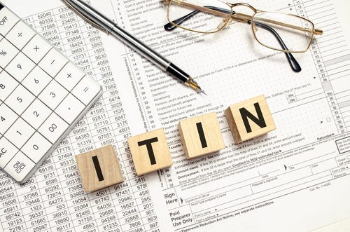 ITIN word on wooden block with calculator and pen