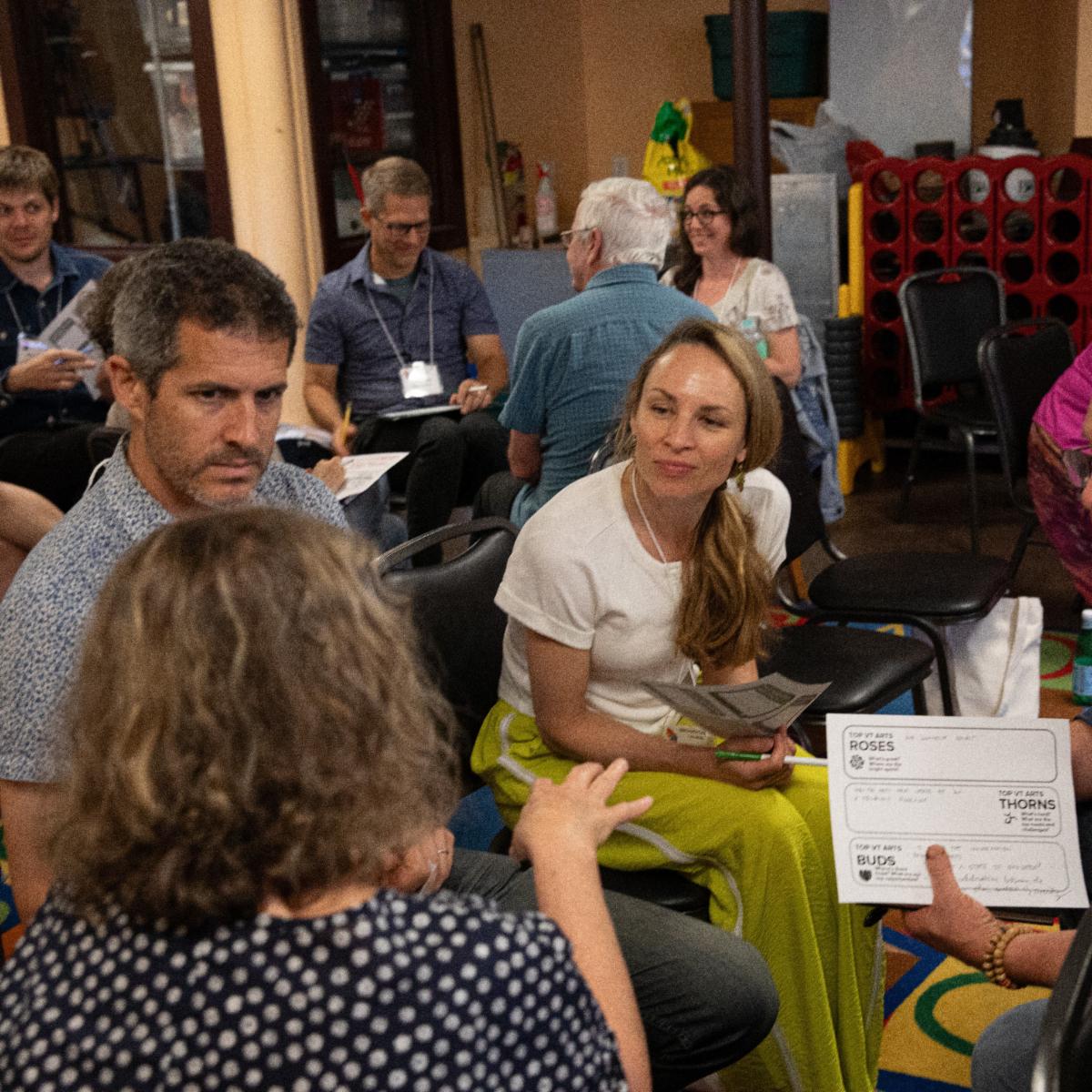 A group of people sitting in a circle talking