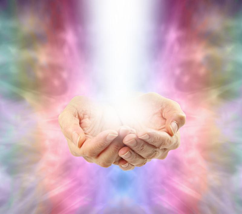 Healer s cupped hands with shaft of healing energy flowing upwards on an Angelic rainbow colored background