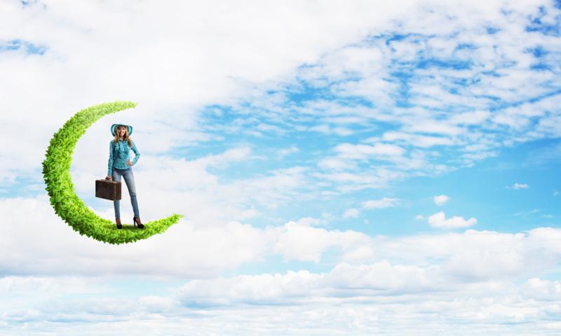 Beautiful woman traveler in hat with suitcase on green moon