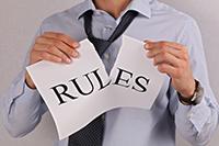 Photo of a man tearing the word Rules in half