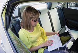 Photo of a woman working in the backseat of a car