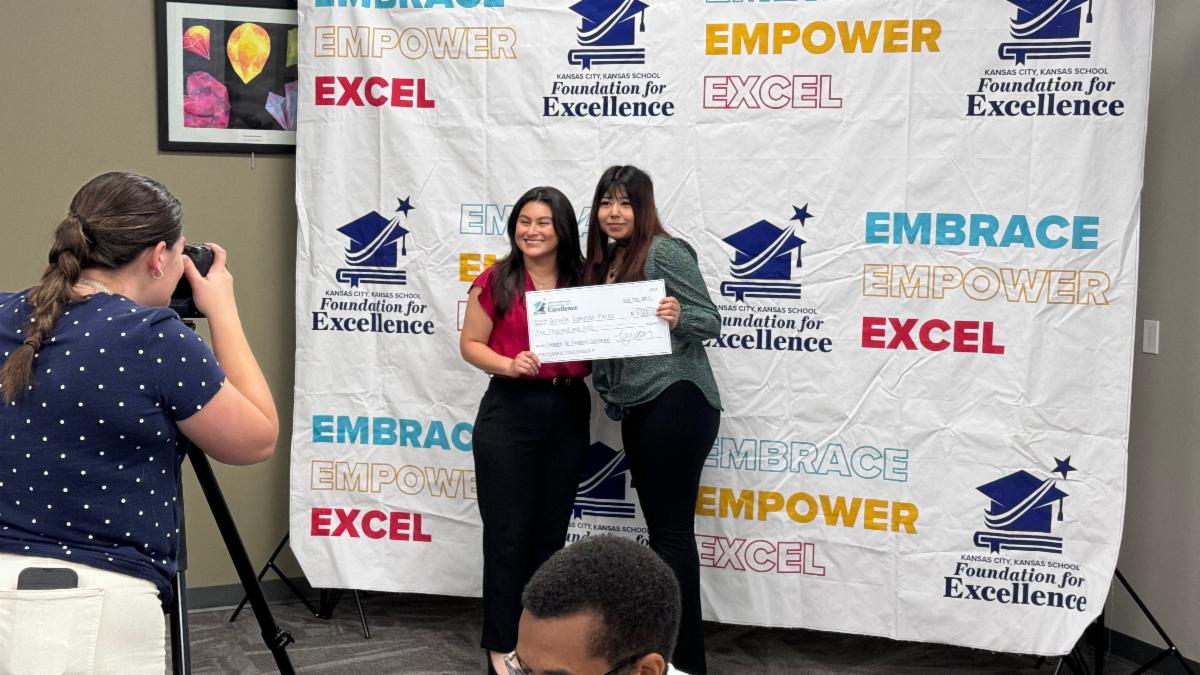 A Schlagle HS teacher and student posed with a check from the KCK Foundation