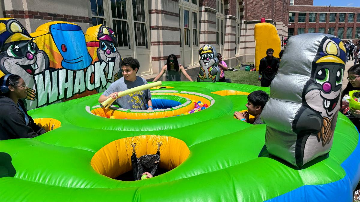 students at Wyandotte HS are playing in an inflatable whack-a-moe game